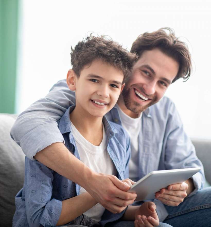 family-time-happy-dad-and-son-using-digital-tablet-browsing-internet-online-at-home-sitting-e1632233068896.jpg